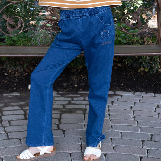Child modeling blue Sweetie Pant with an elastic waistband, star patch, and a bow at the ankle.