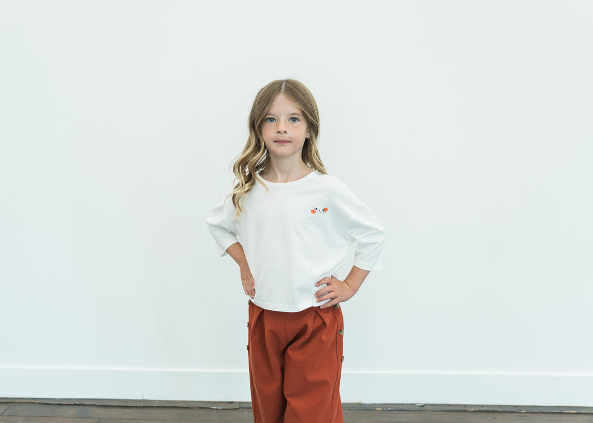 Child wearing the ivory Cat Nap Tee with a cat graphic and relaxed sleeves