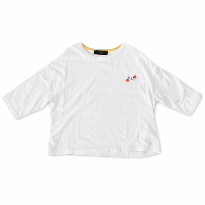 White Cat Nap Tee with relaxed sleeves, yellow inner neckline and a small black cat face with orange accents.