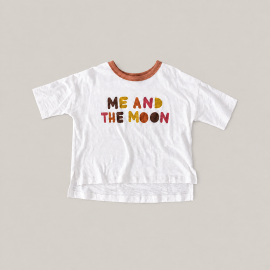 White Luna Graphic Tee with a brown neckline, colorful ME AND THE MOON lettering and a longer back hem.