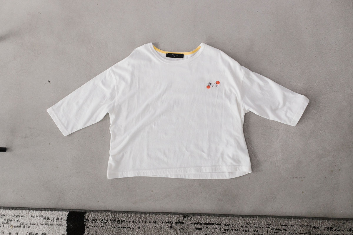 The white Cat Nap Tee is shown flat with a small cat-face graphic and orange accents on the chest.
