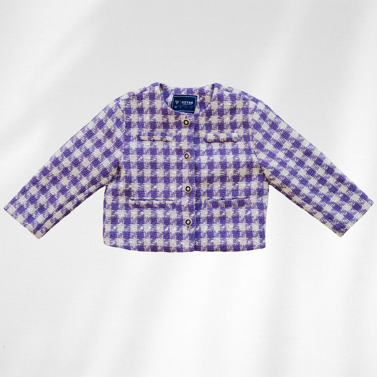 The Uptown Girl Jacket is shown flat with purple-and-cream checks, four round front buttons and flap details.
