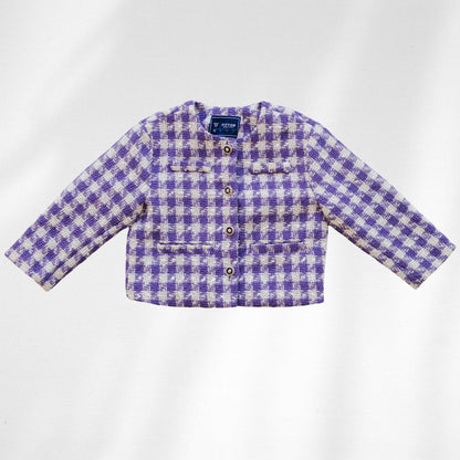 The Uptown Girl Jacket is shown flat with purple-and-cream checks, four round front buttons and flap details.